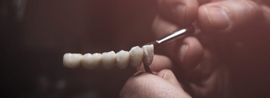 A dental technician makes a prosthetic teeth. laboratory. close-up